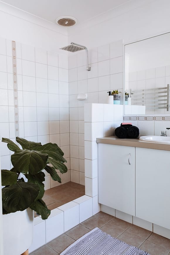bathroom with open shower and green leafy plants